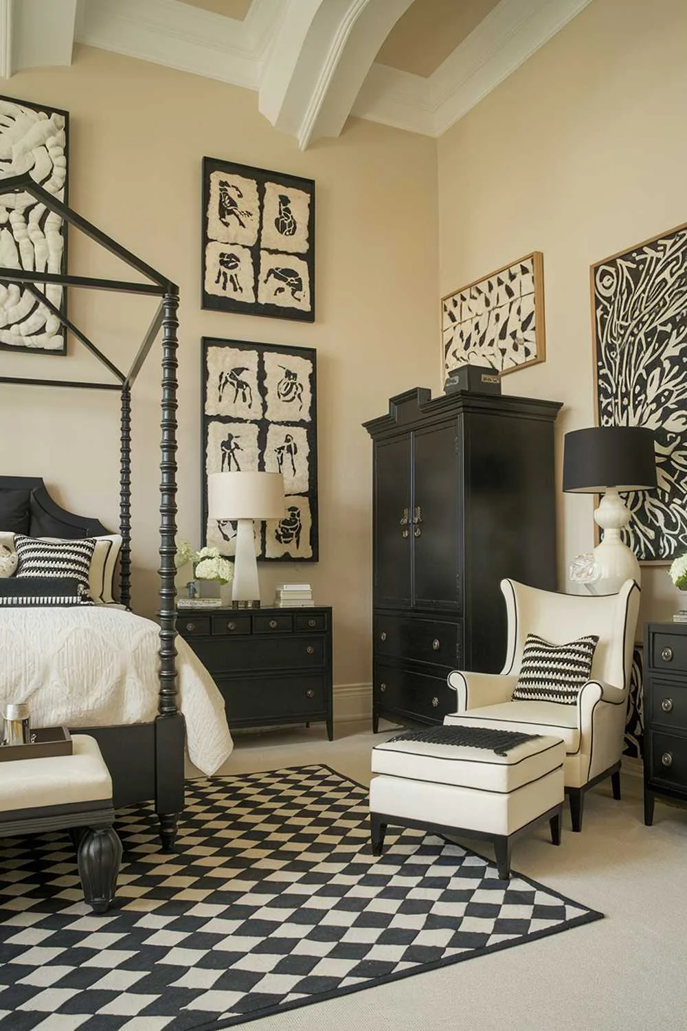 A black and cream bedroom design and decor. The room has a high ceiling and is furnished with a black four-poster bed with cream bedding, a black wardrobe, a black dresser, and a cream chair with a black footstool. There is a black lamp on the dresser and a cream lamp on the nightstand. The walls are adorned with black and cream artwork. The room has a black and cream area rug. The background wall is painted in a soft beige color.