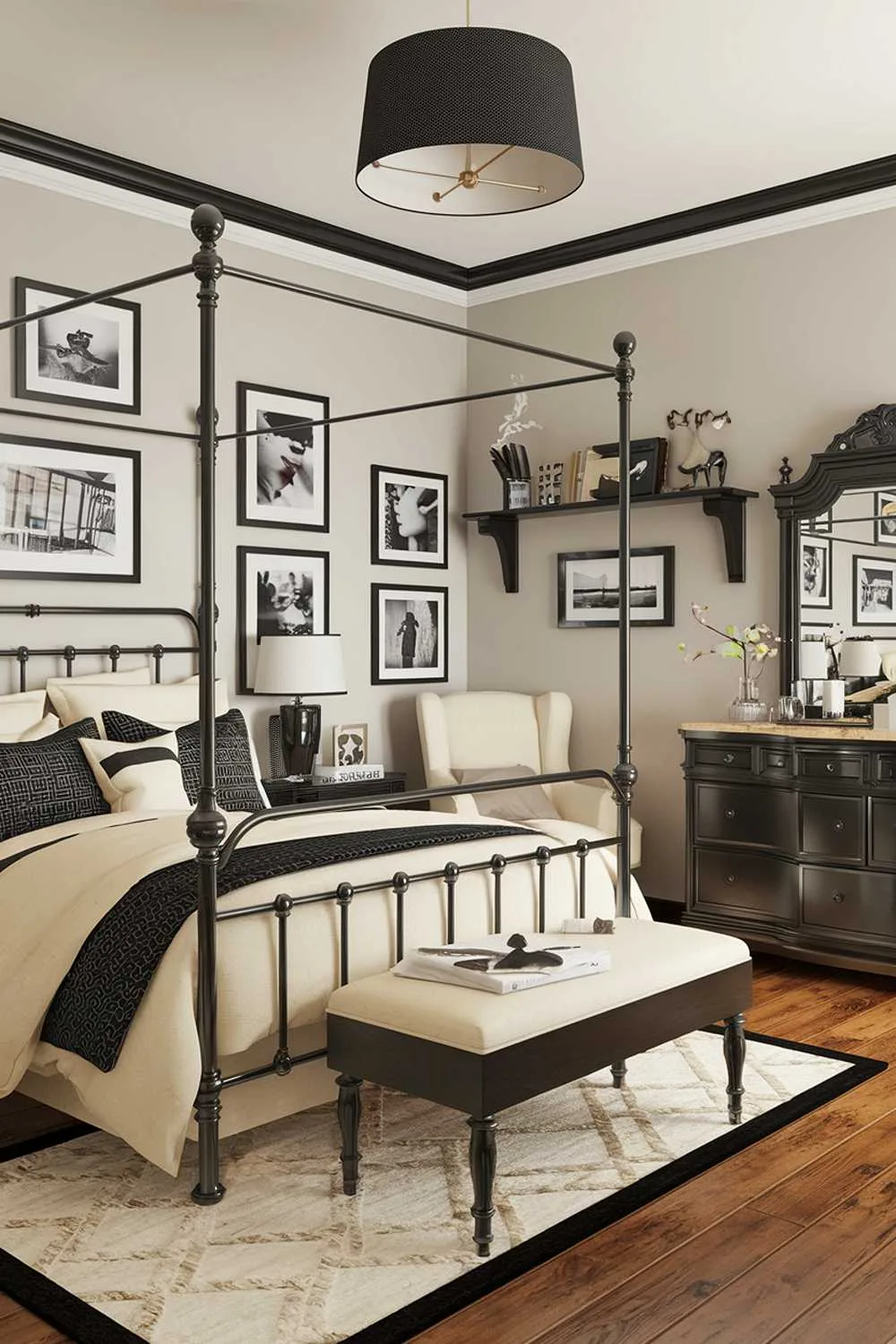 A black and cream bedroom design and decor. The room has a black metal canopy bed with cream bedding. There's a black dresser with a mirror and a cream chair. The walls are adorned with black and white photos in black frames. The floor is made of wooden planks. There's a cream rug beneath the bed. The room has a black lampshade on a wooden stand. The wall has a black shelf with decorative items.